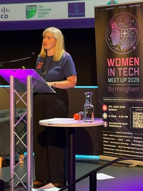 Becky Patel speaking on stage at Women in Tech Meet Up 2026